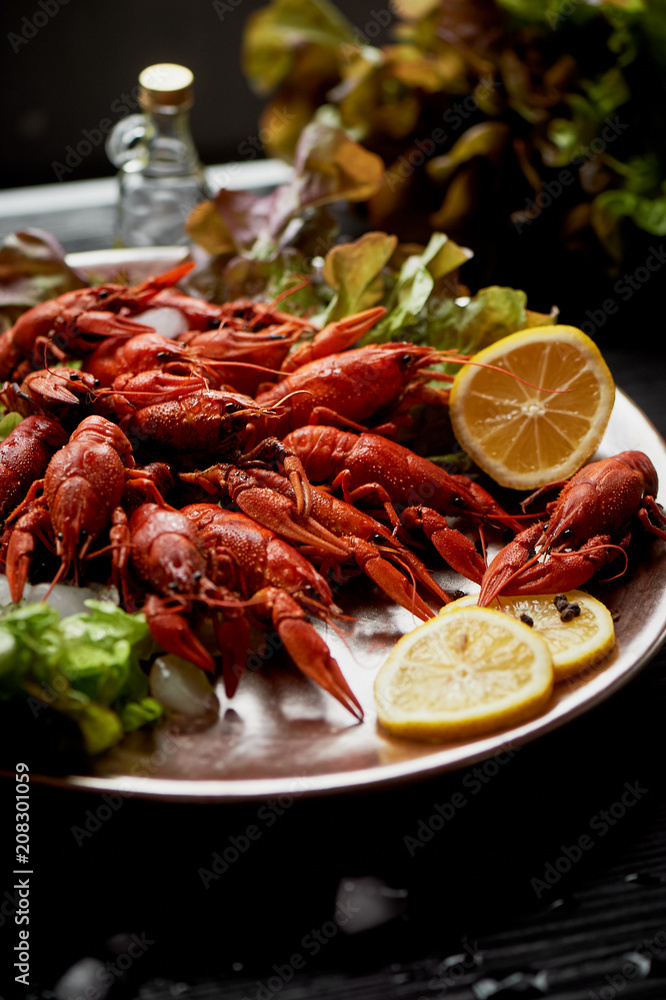 A lobster on a big Golden platter. Scatter the lemon and the Bay leaf.Restaurant food. A lobster on a big Golden platter. Scatter the lemon and the Bay leaf.Restaurant food.