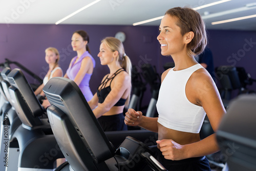 Portrait of young fitness women jogging on treadmill