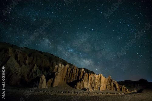 Milky way and late night stars raising over rugged desert landscape