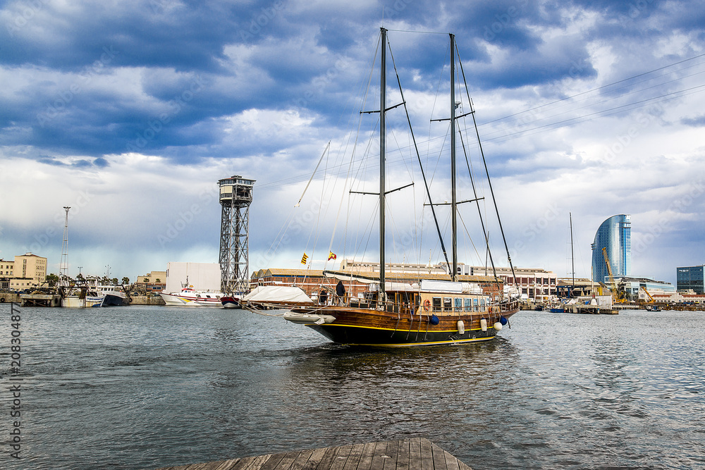 The yacht sails in the port of Barcelona, Spain.