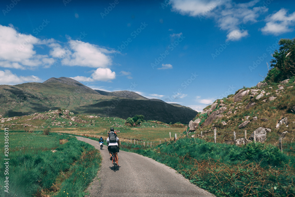 Obraz premium People riding bicycles on the scenic roads of Black Valley in county Kerry, Ireland