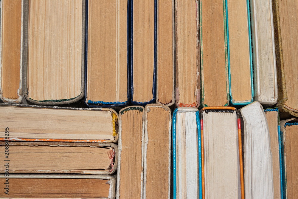 background, defocusing. Old books neatly stacked on the shelf