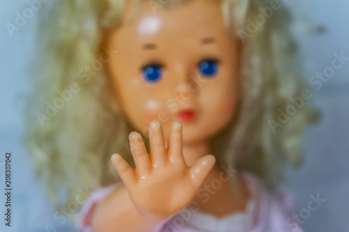 Close-up of beautiful plastic doll with blond hair and blue eyes, sky blue vintage dress and leather shoes. Little princess games.
