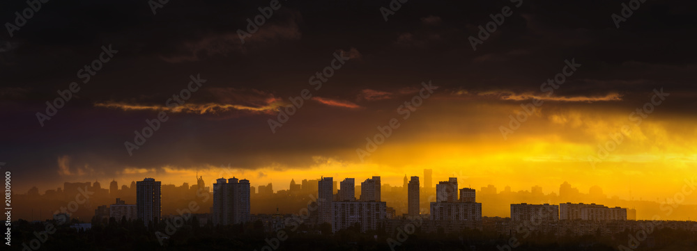 Awesome stunning evening sunset in dramatic sky. Panoramic cityscape big town silhouette in incredibly bright sunshine through hard rain. View to downtown from left bank Dnipro river. Kyiv. Ukraine.
