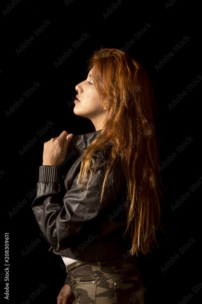Redhead latin girl with black jacket on black background Redhead latin girl with black jacket on black background