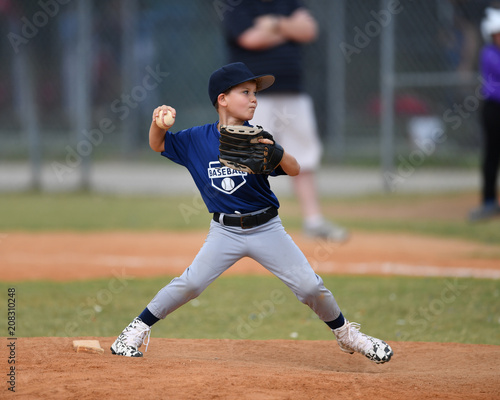 Young boy pitching the ball in a baseball game photo