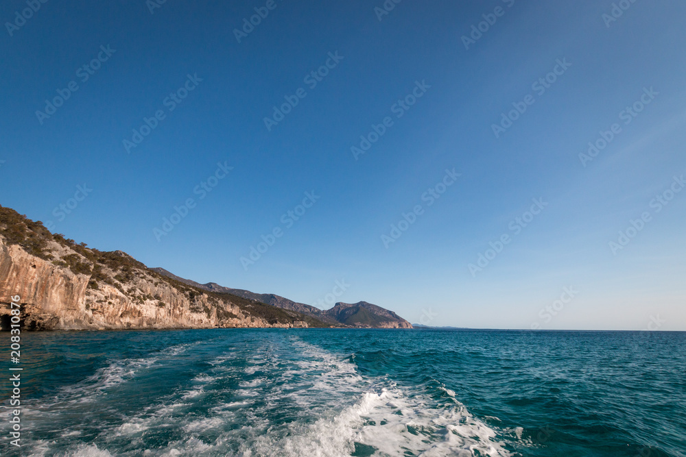 Gulf of Orosei with Cala Gonone and wake behind motor boat