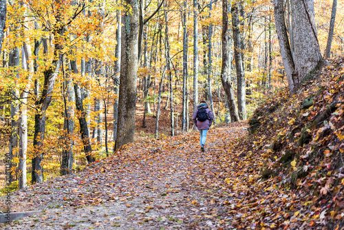 Фотография Hiking trail in Harper's Ferry with hiker, young woman in cold coat walking thro