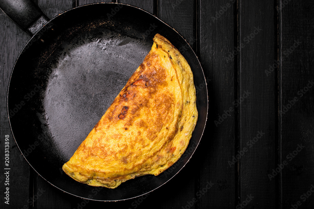 custom made wallpaper toronto digitalDelicious Classic French Omelet still on a cast iron pan, on top of a rustic black wooden background