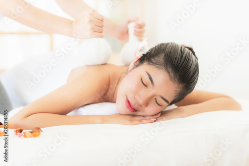  Woman getting massage with compress herbal balls