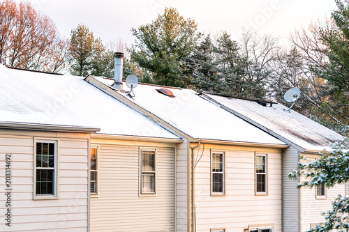 Bilde på lerret Closeup of house townhomes rowhouse rooftop roof with chimneys covered in white