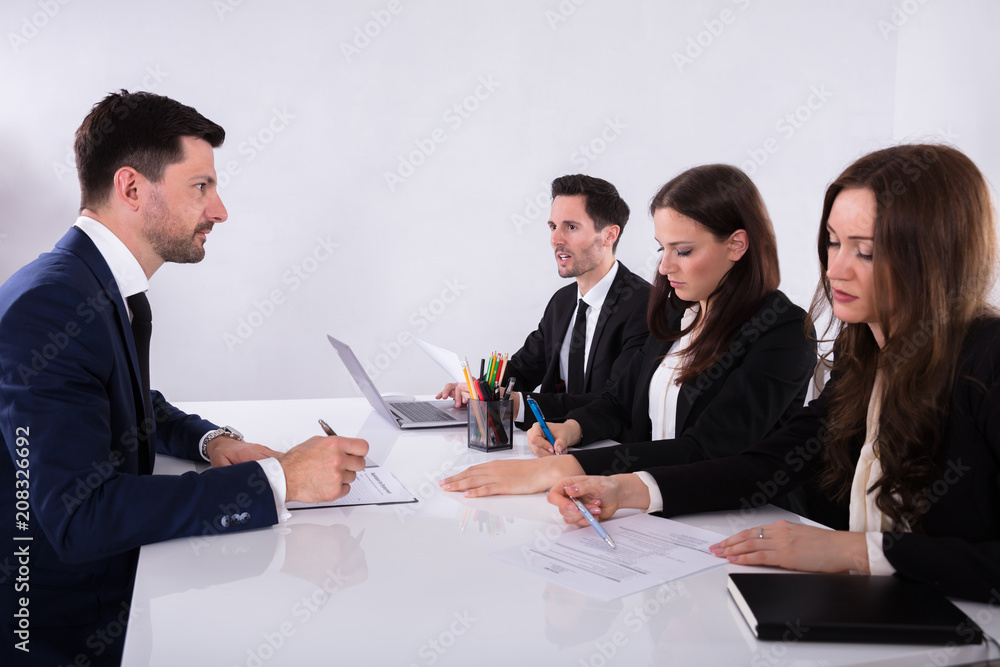 Group Of Businesspeople Discussing Paperwork Group Of Businesspeople Discussing Paperwork