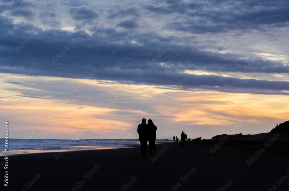 Couple walking in the beach at sunset