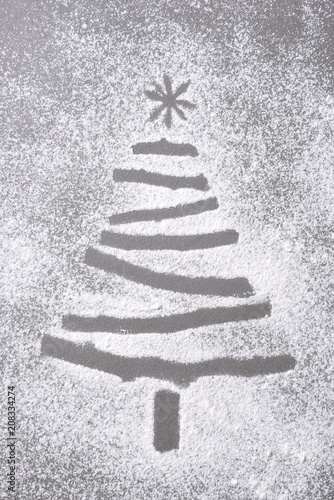 Christmas tree shape in flour sprinkled on a baking sheet