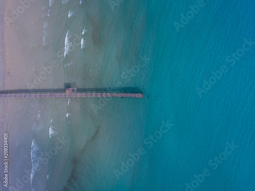 Aerial view A wooden bridge extends to the sea.