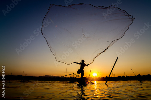 Fisherman casting his net at sunrise on the Mekong River in Thailand.