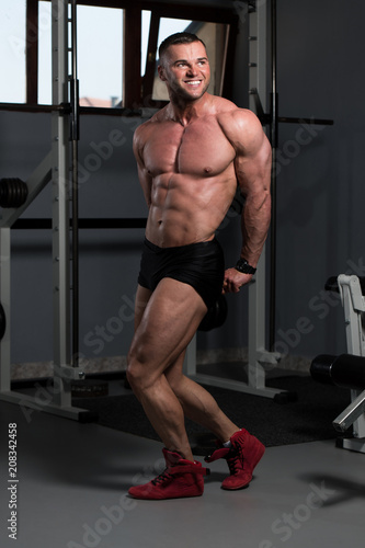 Handsome Muscular Man Flexing Muscles In Gym