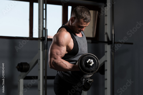 Biceps Exercise With Dumbbells In A Gym