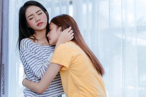 Same sex asian lesbian couple lover embrace and kiss erotic scene in the bedroom happiness feeling, LGBT sexuality female hug living together at home.