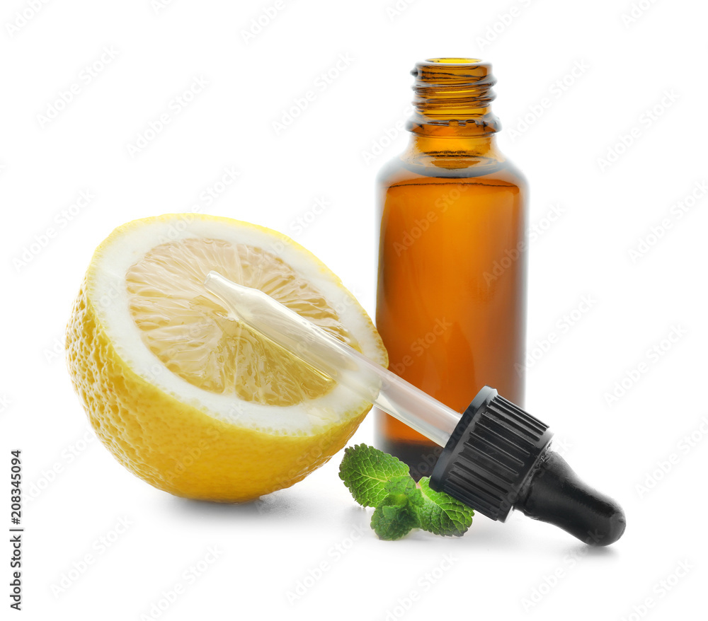 Bottle of citrus essential oil and lemon on white background Bottle of citrus essential oil and lemon on white background