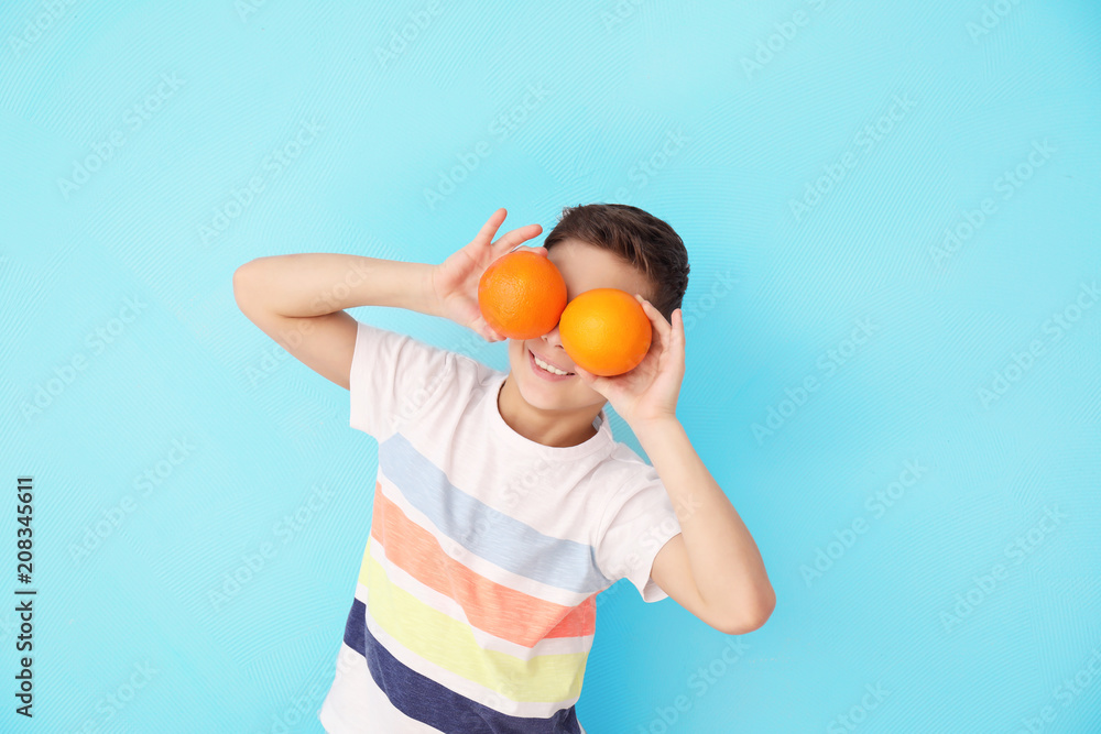Funny little boy with citrus fruit on color background Funny little boy with citrus fruit on color background