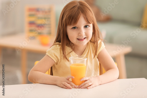 Funny little girl with citrus juice at home