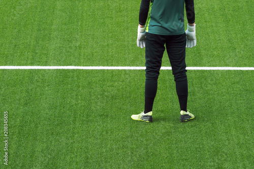 Soocer goalkeeper on green grass background