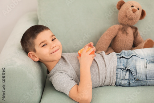 Funny little boy eating cit...