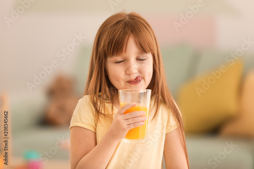 Bild auf Leinwand Funny little girl drinking citrus juice at home