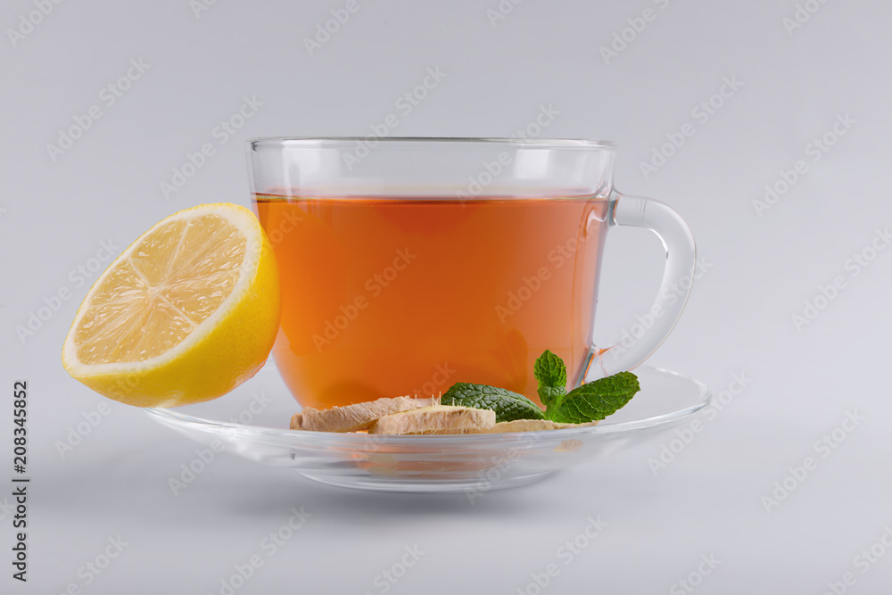 Cup of delicious tea with mint, ginger and lemon on grey background