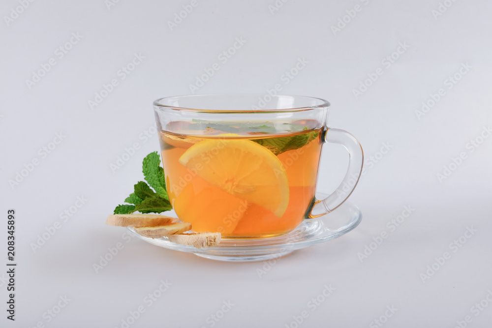 Cup of delicious tea with mint, ginger and lemon on grey background Cup of delicious tea with mint, ginger and lemon on grey background