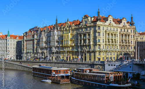 Sightseeing tour boats on river Vltava with the traditional buildings on the bank.