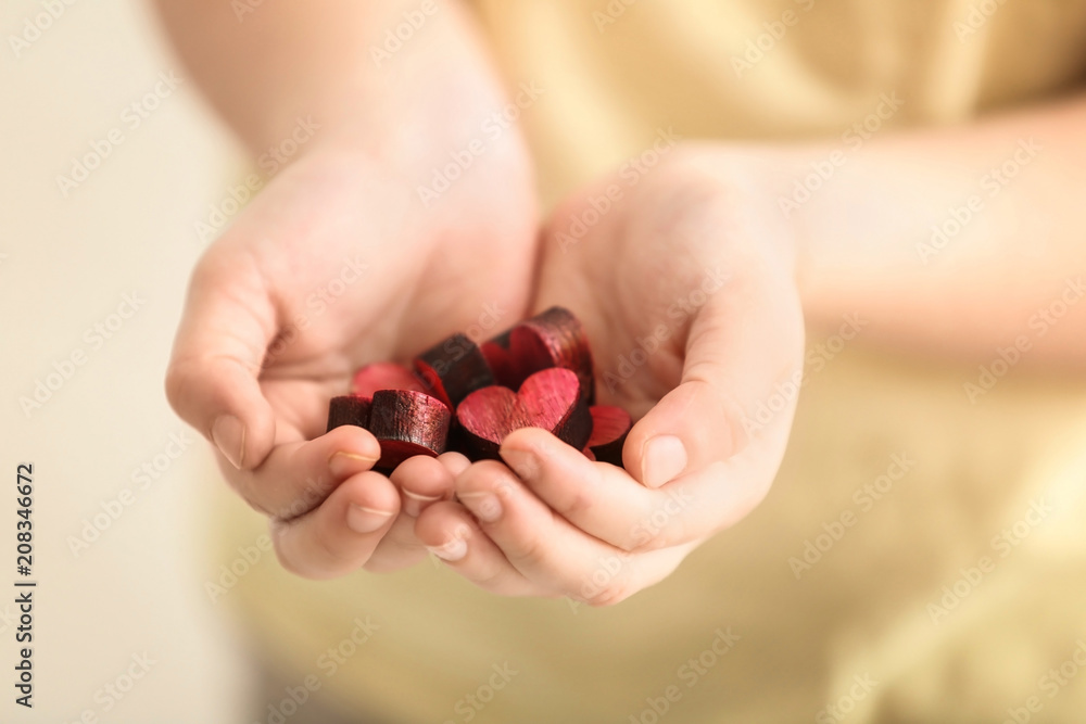 Little girl with handful of small colorful hearts, closeup Little girl with handful of small colorful hearts, closeup