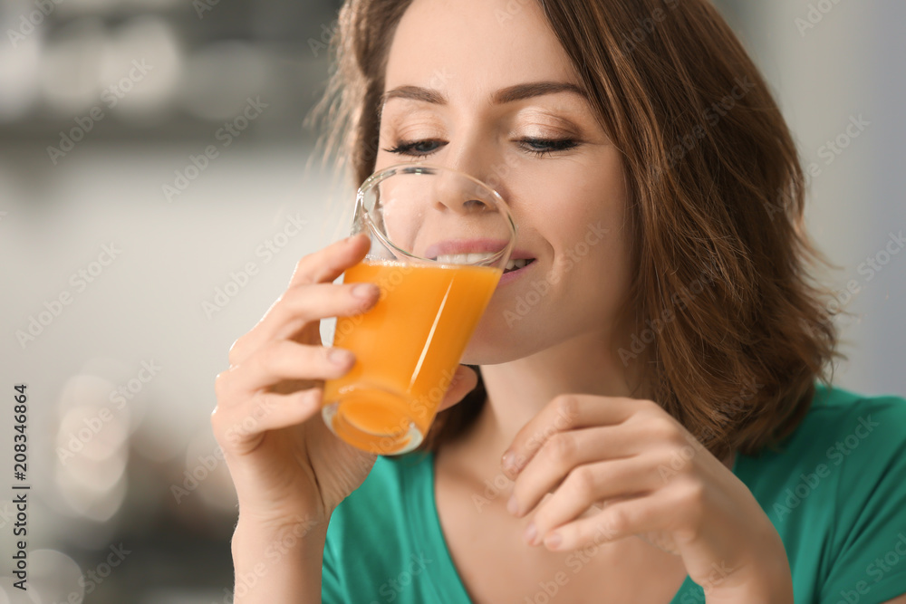 Beautiful woman drinking citrus juice on blurred background Beautiful woman drinking citrus juice on blurred background