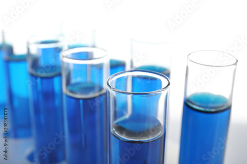 Test tubes with blue liquid on white background