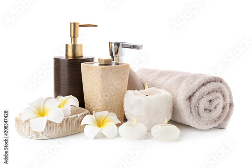 Spa composition with candles, toiletries and clean towel on white background