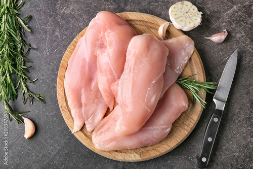 Raw chicken fillet on wooden board