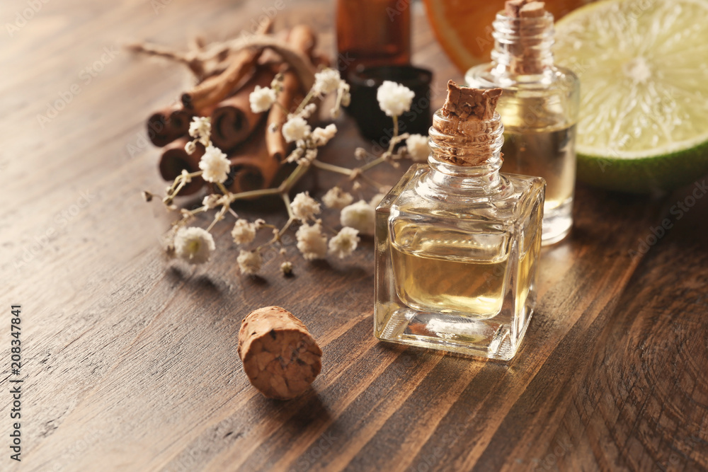 Bottle with citrus essential oil on wooden table Bottle with citrus essential oil on wooden table