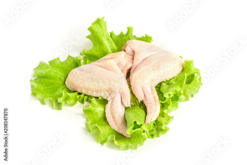 Raw chicken wings and green salad isolated on white background.