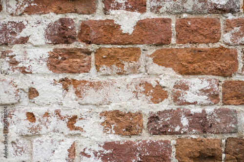 Background of old vintage dirty brick wall with peeling plaster, texture