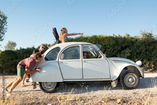 Fototapeta Naklejka Na Ścianę i Meble -  People pushing a broken car