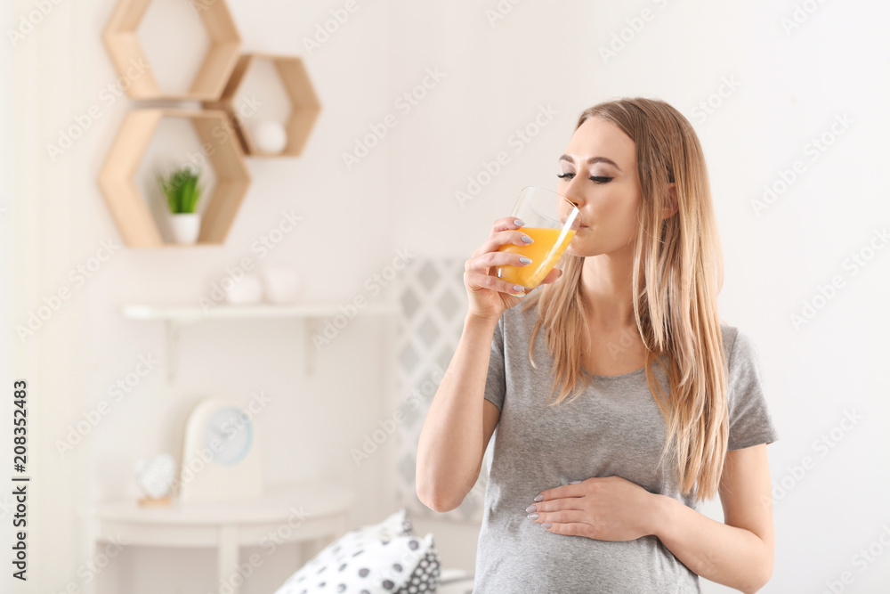 Beautiful pregnant woman drinking citrus juice at home Beautiful pregnant woman drinking citrus juice at home