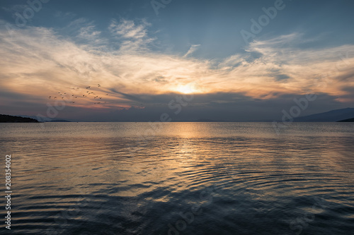 Sonnenuntergang über dem Meer mit aufziehenden Sturmwolken