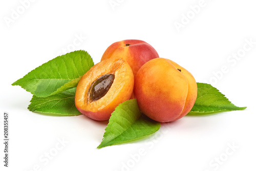 Fresh whole apricots with leaf and half with core, isolated on white background. photo