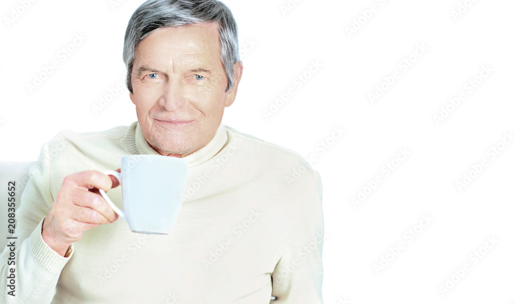 Portrait of senior man holding coffee mug, smiling at camera