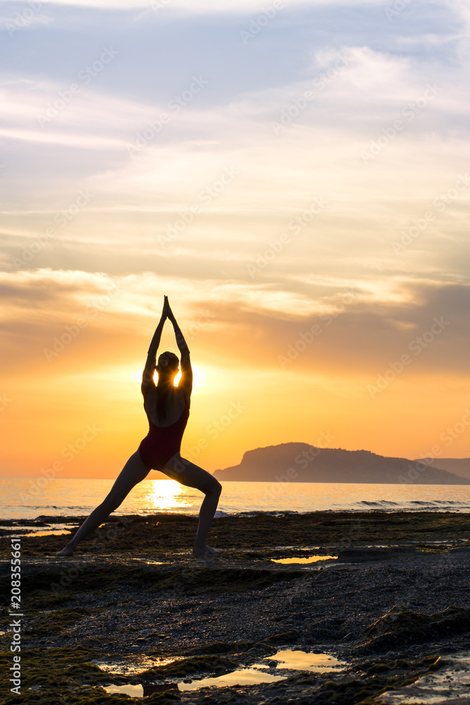 Meditation girl on the sea during sunset. Yoga silhouette. Fitness and healthy lifestyle