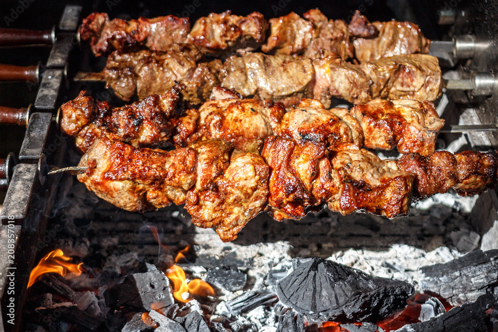 Shish kebabs with grilled meat for barbecue. Close-up pieces of juicy meat on skewers. Preparation of traditional shashlik. B-B-Q. Selective focus