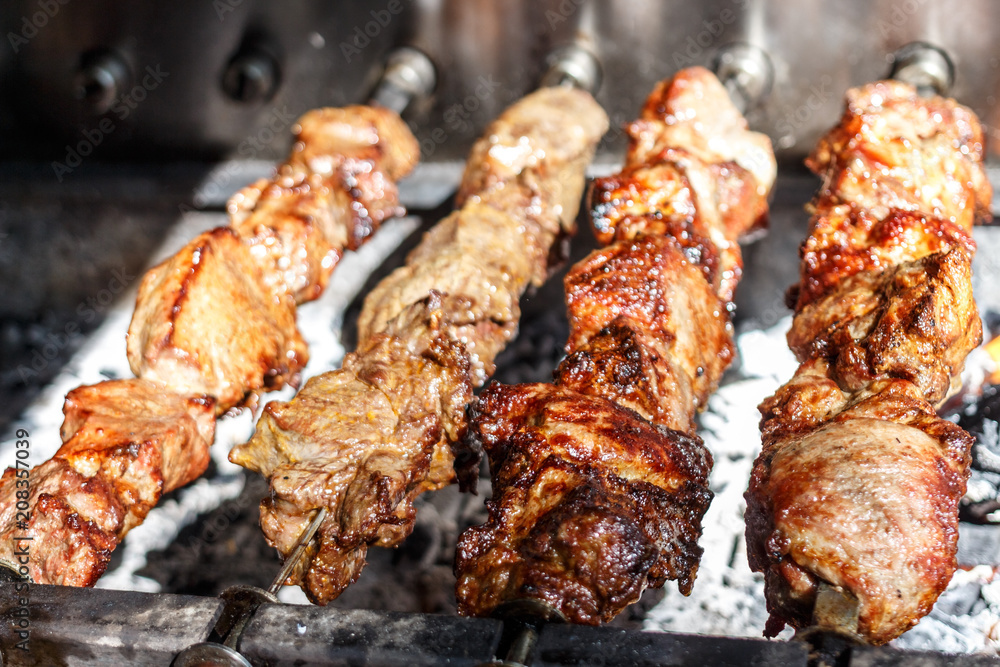 Shish kebabs with grilled meat for barbecue. Close-up pieces of juicy meat on skewers. Preparation of traditional shashlik. B-B-Q. Selective focus