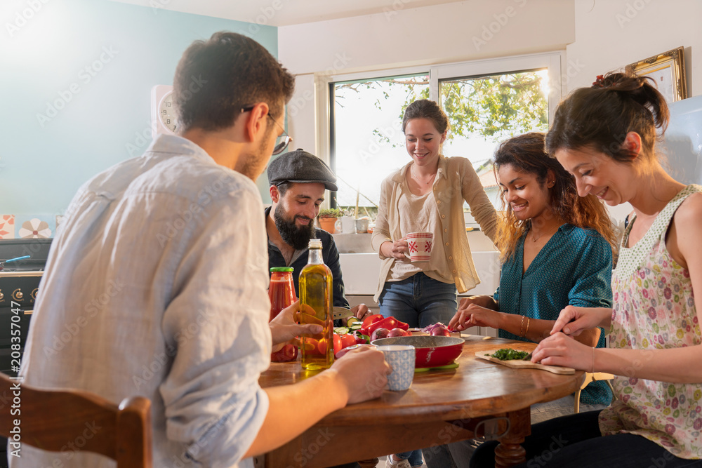 Multi-ethnic group of friends cooking lunch in the kitchen. Multi-ethnic group of friends cooking lunch in the kitchen.