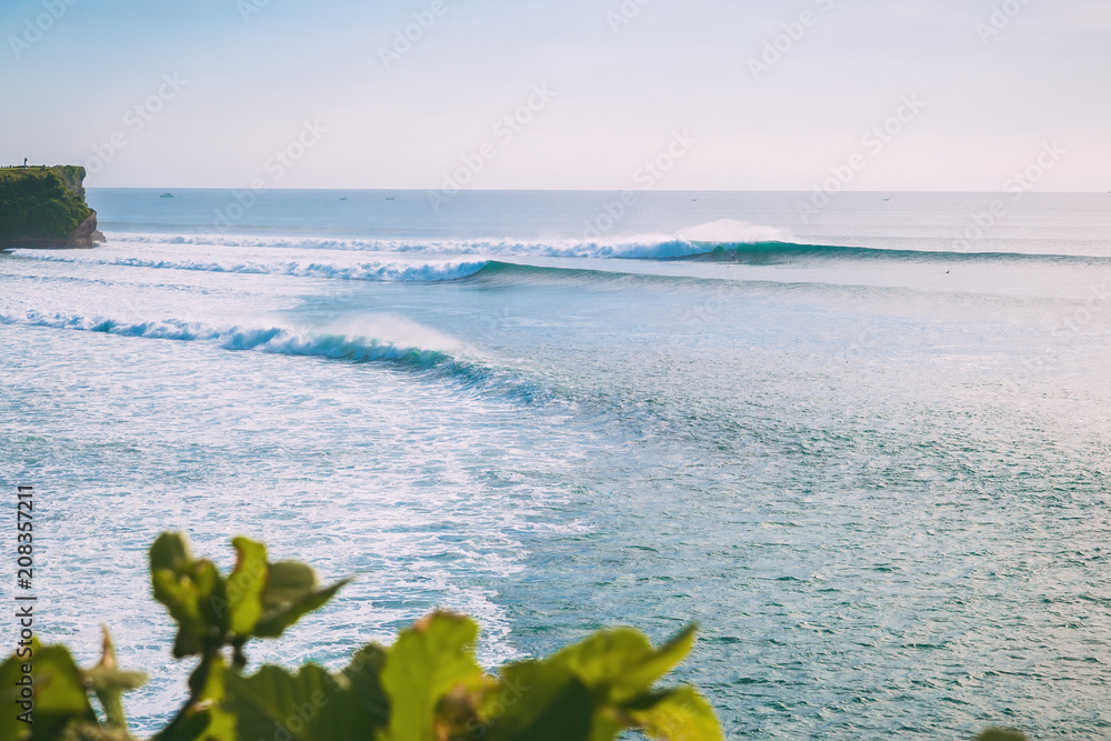 Tropical beach and big ideal waves for surfing in Bali. Ocean waves in Indonesia Tropical beach and big ideal waves for surfing in Bali. Ocean waves in Indonesia